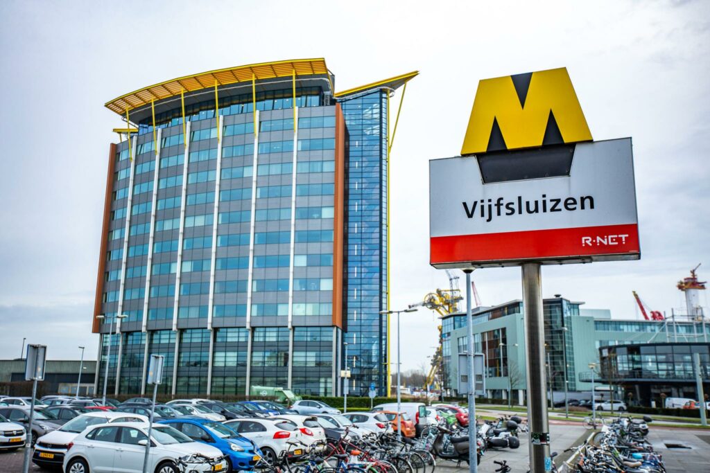 Metrostation Vijfsluizen met op de achtergrond een modern kantoorgebouw aan de Karel Doormanweg.